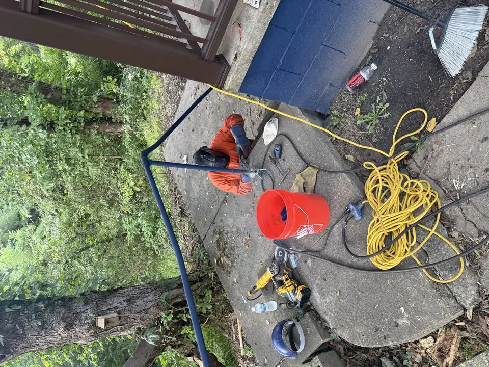 Metal handrail welding repair beside a concrete walkway
